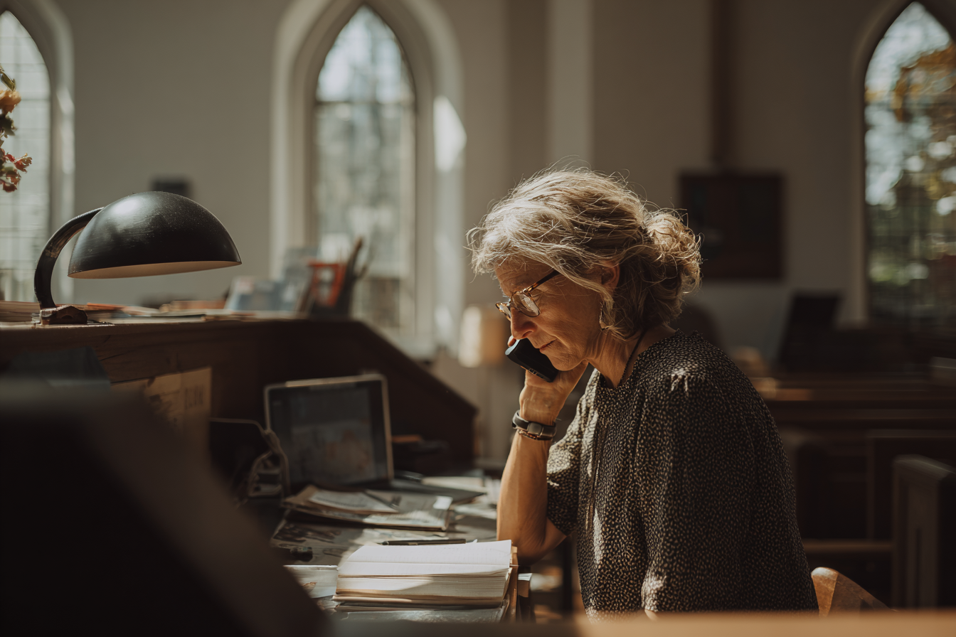 A church administrator at her desk answering a call